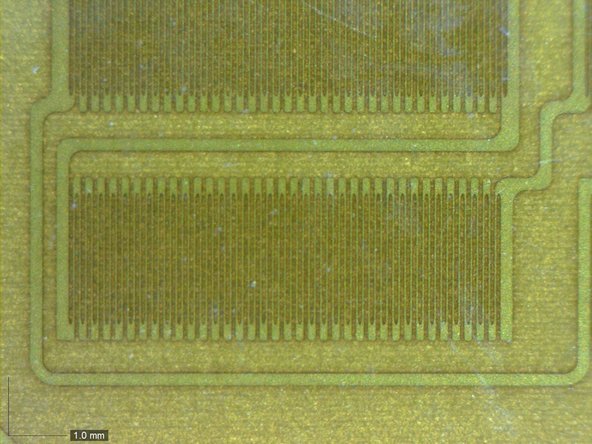 Image 3/3: Based on the wiggly pattern of traces stuck to the metal tabs, we're pretty sure the magic pressure sensors in the new Force Touch trackpad are tiny [http://en.wikipedia.org/wiki/Strain_gauge|strain gauges|new_window=true]. Mounted on flexing metal supports, they detect the amount of flex on each—and based on that, the force from above.