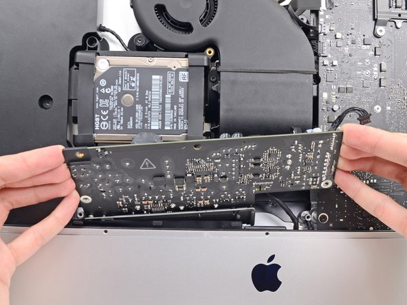 Image 2/3: '''Do not''' try to completely remove the power supply from the iMac yet—it is still connected to the logic board.