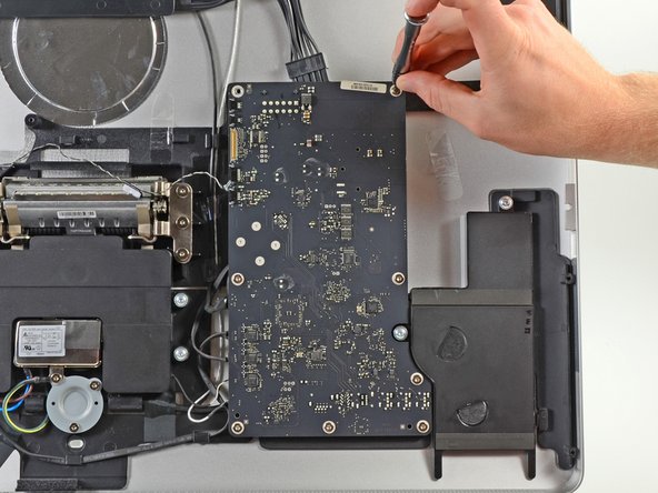 Image 2/3: A few more T10 Torx screws bite the dust at the hand of our bit driver kit, and the logic board is detached.