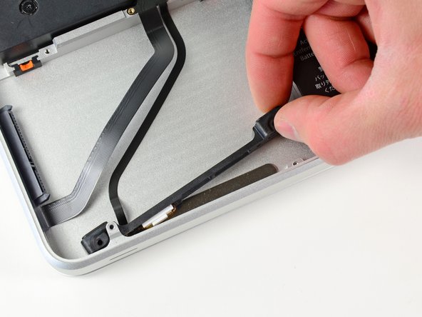 Image 1/3: Carefully peel the hard drive and IR sensor cable from the upper case.
