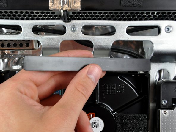 After the left edge has been freed, rotate the bracket toward the right edge of the hard drive.
