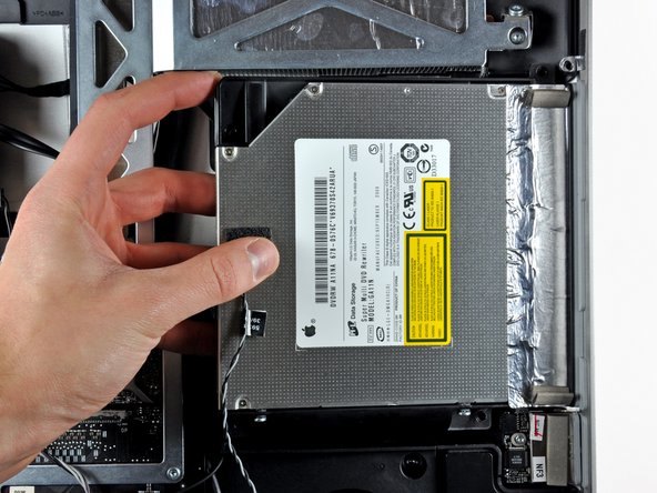 Image 1/1: During reassembly, note that there are two holes in the optical drive face plate into which two stubby plastic posts must engage for proper positioning.