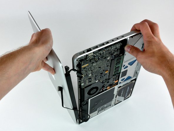 Image 3/3: Lift the display away from the upper case, minding any brackets or cables that may get caught.