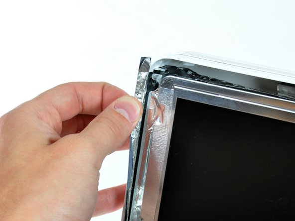 Image 1/1: During reassembly, it is helpful to use several small strips of tape to hold the EMI shielding along the left and right edges of the display footprint out of the way before lowering the display into the rear case of your iMac.