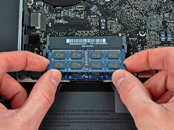 Image 2/2: After the RAM chip has popped up, pull it straight out of its socket.