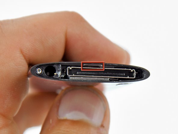 Image 1/2: Use the metal spudger to pry up the bottom edge of the click wheel.