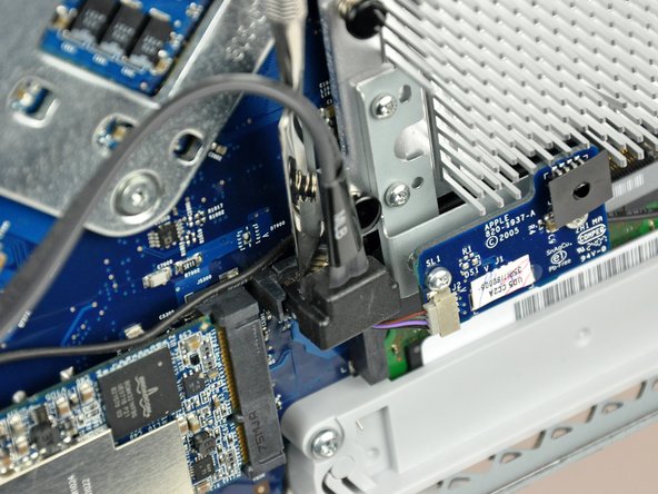 Image 2/2: The SATA connector on most iMacs tends to stick in its socket on the logic board. If you are having trouble disconnecting the SATA cable, insert a [product|IF145-012|metal spudger] or any other thin tool into the gap between the SATA connector and its socket and twist the spudger's shaft to safely separate the two pieces.