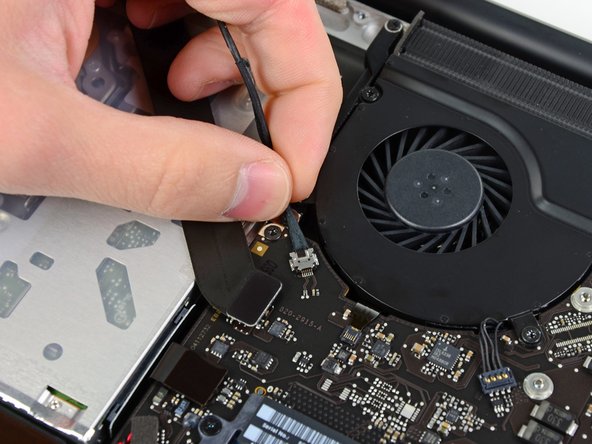 Image 1/1: Pull the cable parallel to the face of the logic board toward the optical drive opening.