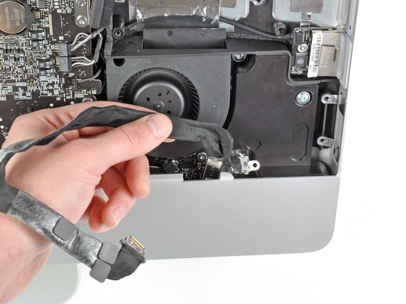 Image 1/2: Another leftover from the previous generation, the IR board, can simply be lifted straight up and removed from the iMac's front bezel.