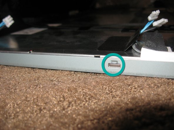 Image 2/3: Locate the lock tabs on either side of the LCD panel.  There are 2 on each side