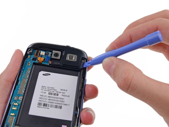 Image 1/2: Insert a plastic opening tool outboard of the speaker portion of the headphone jack/speaker assembly.