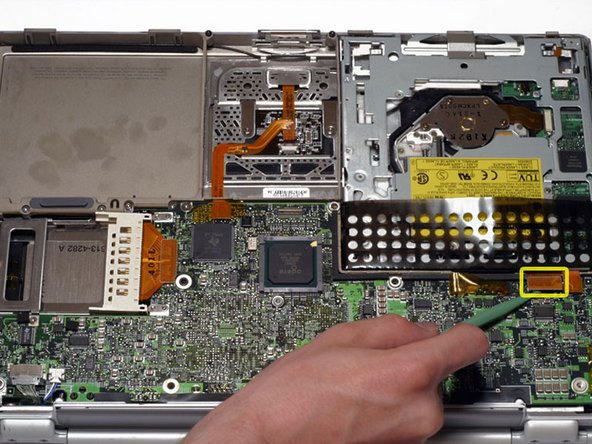 Image 1/1: Disconnect the orange DVD ribbon cable from the logic board using a spudger or the tip of your finger