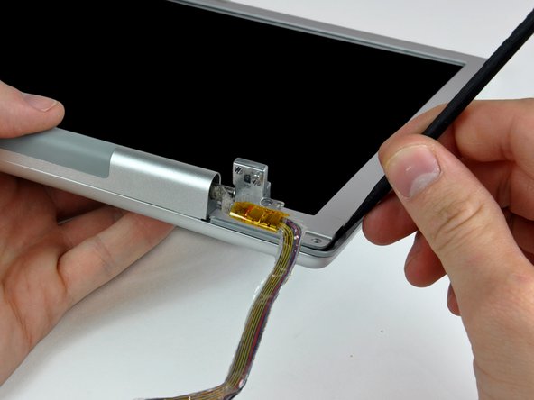 Image 1/2: Pry the rear bezel away from the front bezel to slightly separate the bottom edge of the rear display bezel.