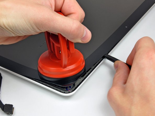 Image 2/3: Pry up the glass panel a few inches away from the upper right corner along the top and right edges of the display.