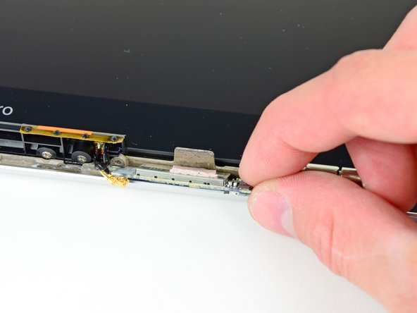 Image 1/2: Before installing a new AirPort card, be sure the thermal material on its surface is intact and aligned with the small heat sink on the display frame.