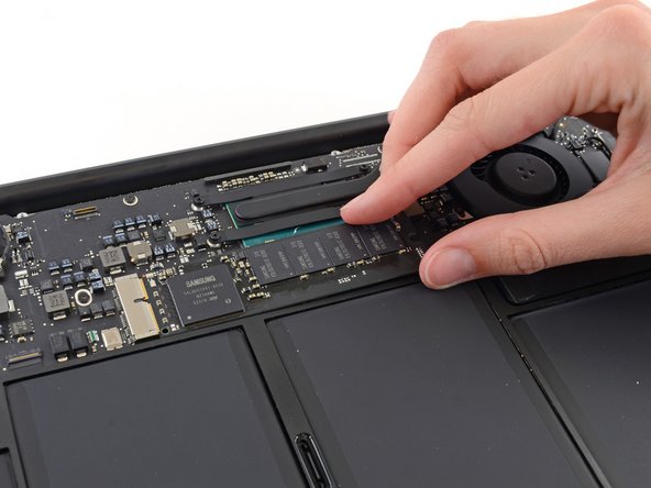 Image 1/2: Don't lift the SSD more than half an inch—doing so may damage the SSD or its socket on the logic board.