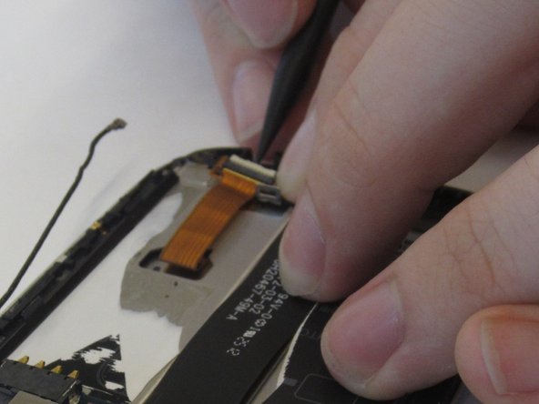 Unlock the gold ribbon cable connecting screen to logic board by lifting the locking tab at the back of the socket.