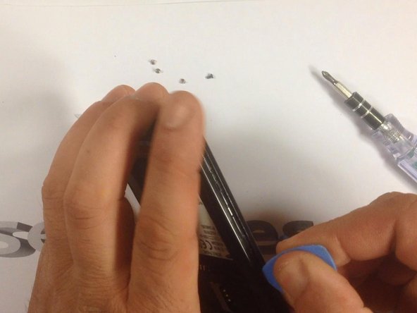 Use a plastic tool to remove the rear housing.