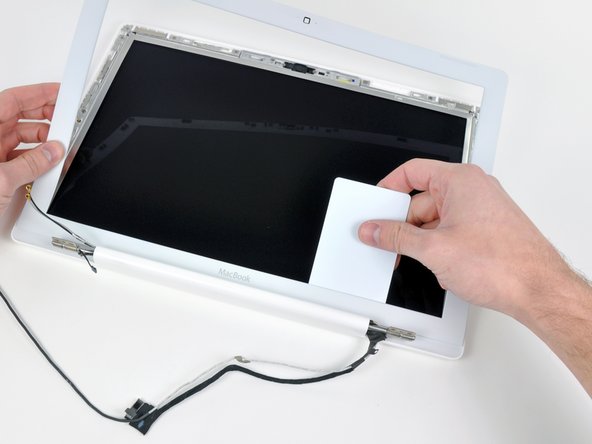 Lift up the front display bezel from the top and use your plastic card to free the tabs along the bottom edge of the display bezel.