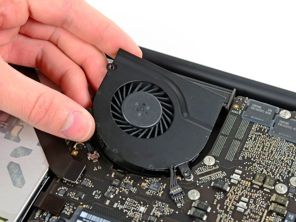 Image 2/2: Lift the right fan out of its opening in the logic board.