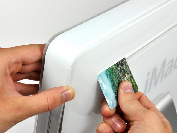 Image 1/3: Insert a plastic card up into the corner of the air vent slot near the top of the rear case.