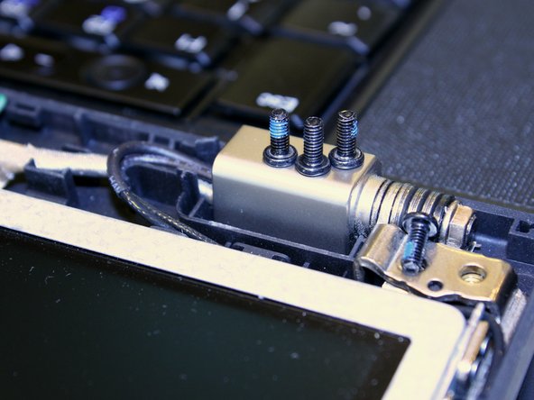 Image 1/3: Carefully rotate the hinges upward just enough to allow the removal of the four screws on the sides of the display frame.