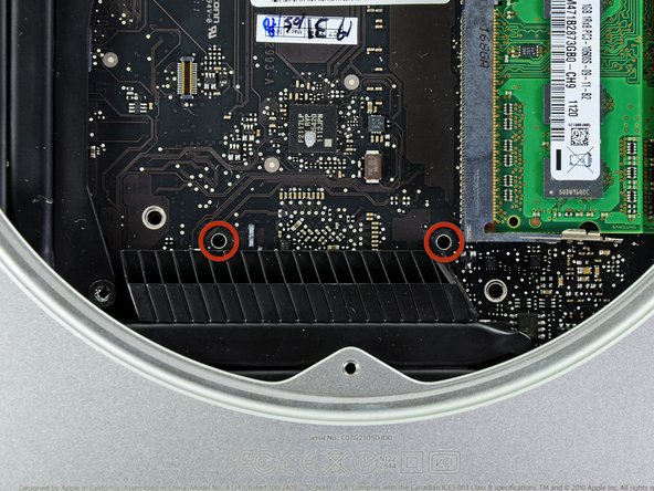 Image 1/3: Insert the [product|IF145-159|Mac Mini Logic Board Removal Tool] into the two holes highlighted in red. Be sure it makes contact with the top side of outer case below the logic board before proceeding.