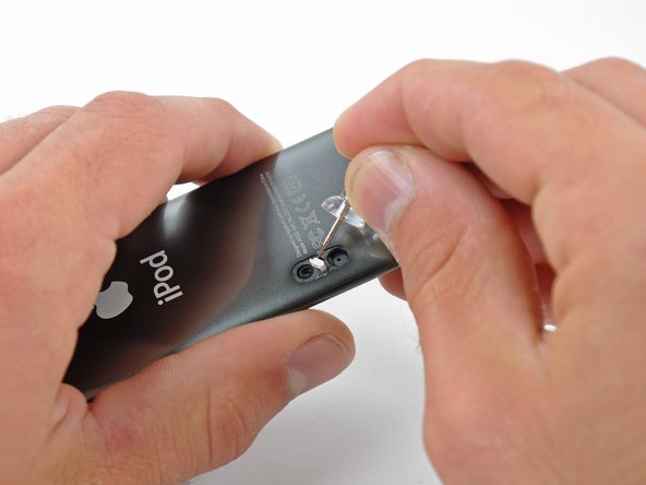 Image 2/3: Insert a push pin into the hole at the corner of the retainer and lift it out of the case.