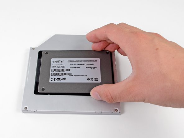 Image 2/3: While firmly holding the enclosure in place with one hand, use your other hand to press the hard drive into the enclosure connectors.