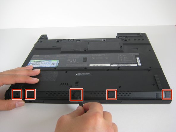 Image 1/1: Remove the five plastic stickers covering the screws on the front edge of the case.