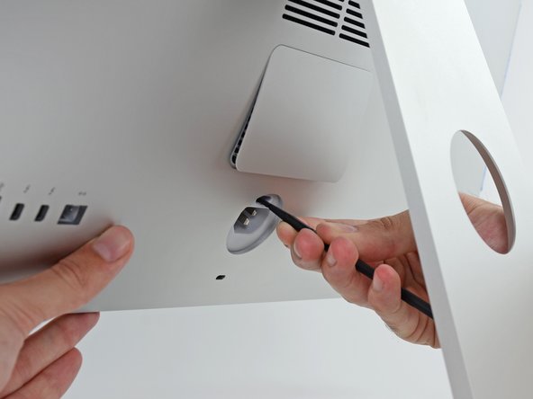 Image 2/2: You may have to press fairly hard—keep at it until the bottom of the door pops out about 0.25" from the rear of the iMac.