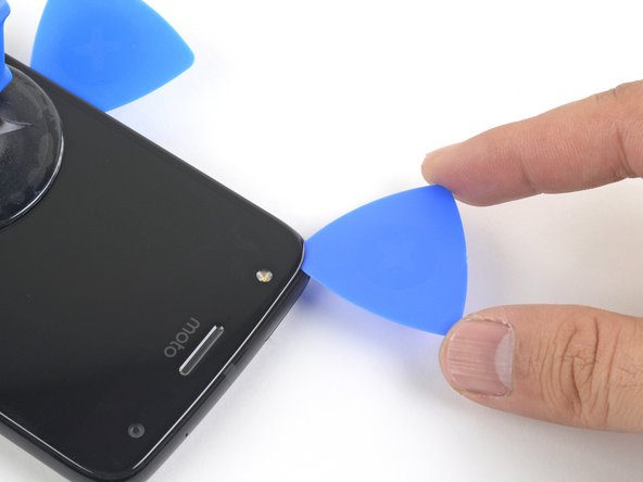 Carefully slice around the corner and through the top edge to separate the adhesive.