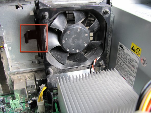 Image 1/1: Locate the release clip on the side of the fan and hold it down with your thumb.