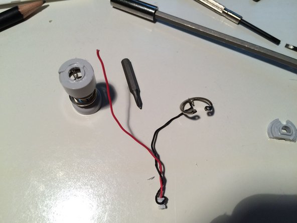 Image 3/3: Also, here is the battery terminal (spring loaded) which had to be forced out.  It's held in the tube by the expansion ring, which unfortunately is the best-made bit of this keyboard.  I forced it out using a long screw driver, but unfortunately broke the wires.  Keyboard had died anyway, thanks Apple.