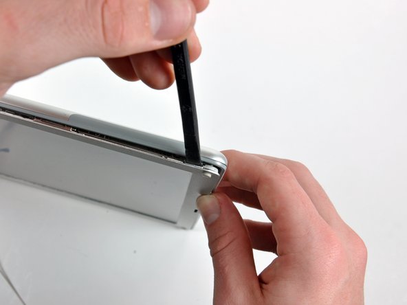 Image 1/2: Release the clip by rotating the spudger away from the screen.