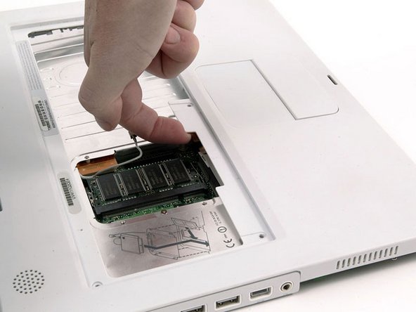 Image 1/1: Lift the upper case and use a spudger or your finger to disconnect the trackpad connector hidden beneath the white plastic tab. Due to model variatons your trackpad connector may be different than the one pictured.