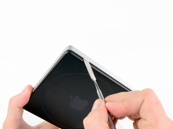 Image 1/2: Lightly pry back to gently lift the clip out of place, just far enough to disengage.