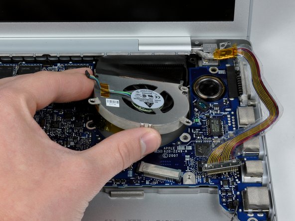 Image 2/2: Lift the right fan up and carefully peel up the tape securing the fan to the heat sink as you go.