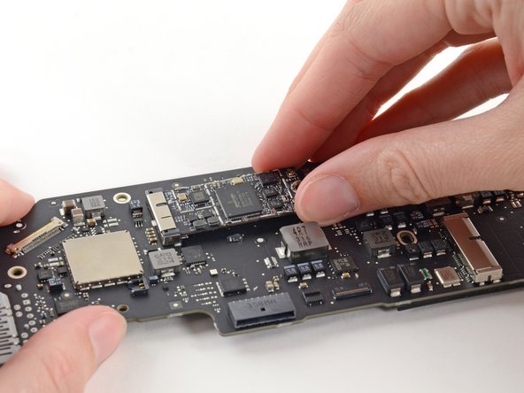 Image 1/2: Slightly lift the free end of the AirPort/Bluetooth board and pull it out of its socket on the logic board.